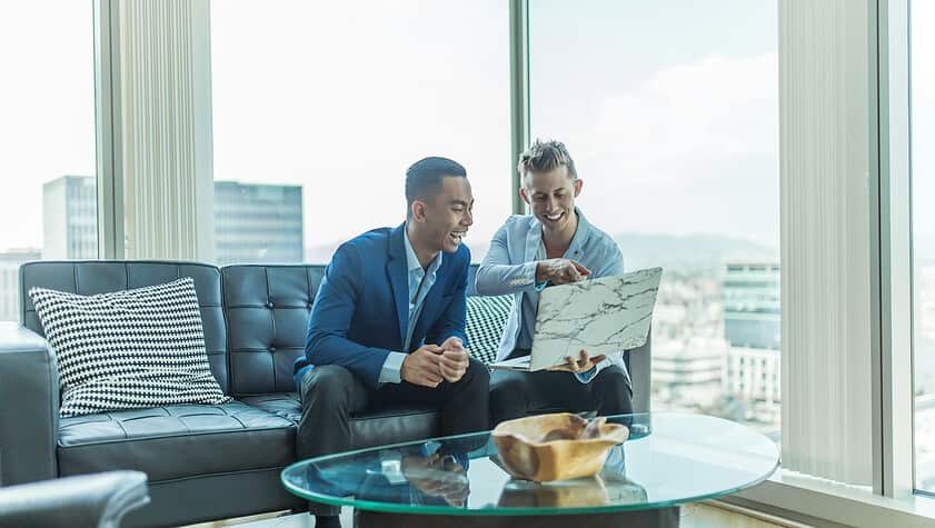 two men in suit sitting on sofa