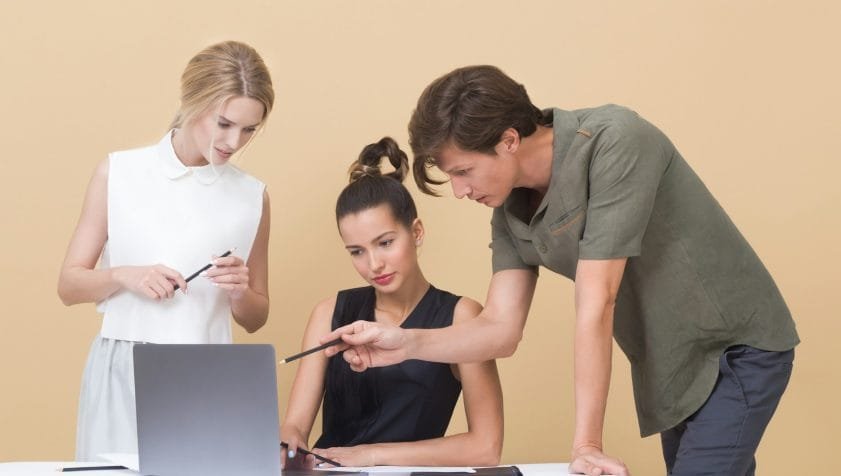 man teaching woman while pointing on gray laptop