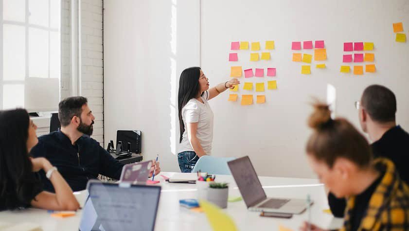 woman placing sticky notes on wall