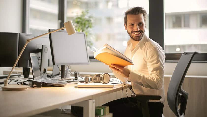 A relaxed businessman enjoying a break in his bright, contemporary office environment.