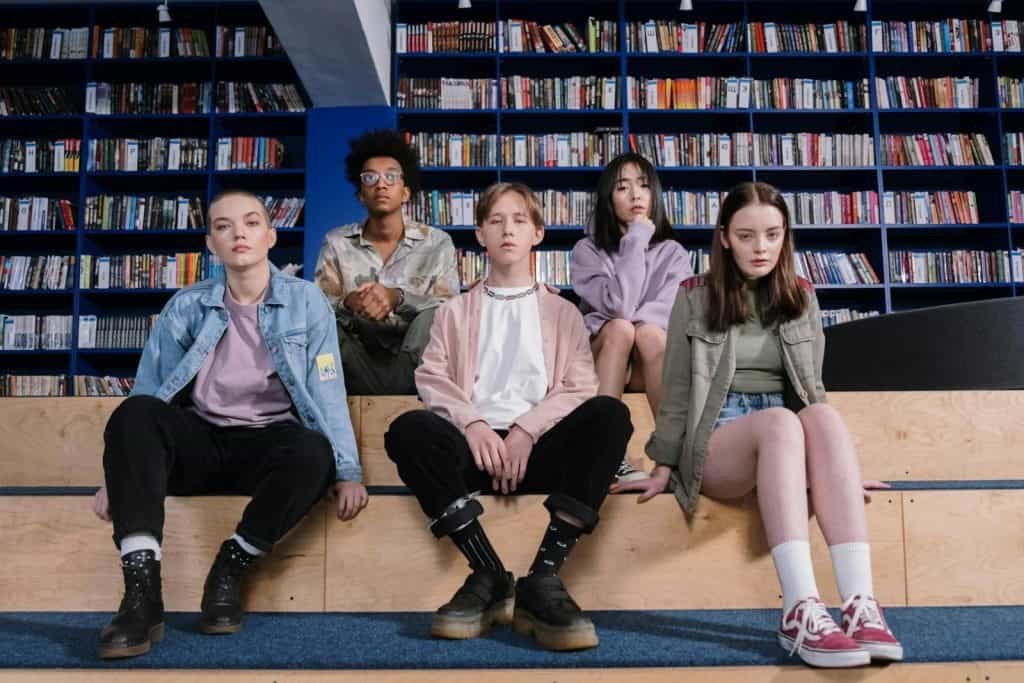 A group of diverse teenagers sitting in a library, showcasing youth diversity and style. Gen Z is redefining success